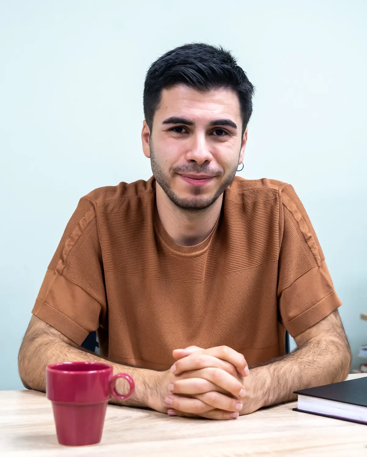 Antalya Psikolog Uzmanı M. Ulaş Kaplan terapi odasında ve masasında kahve içerken profesyonel portre çekiminde